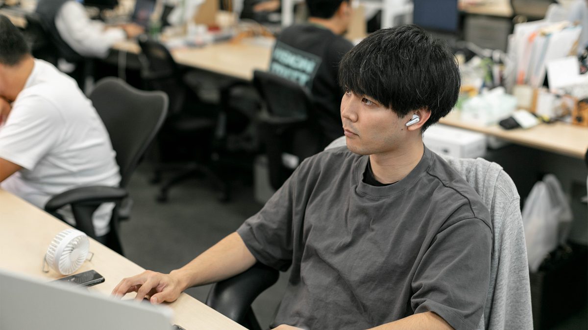 オフィスの開発席でモニターに向かうエンジニア