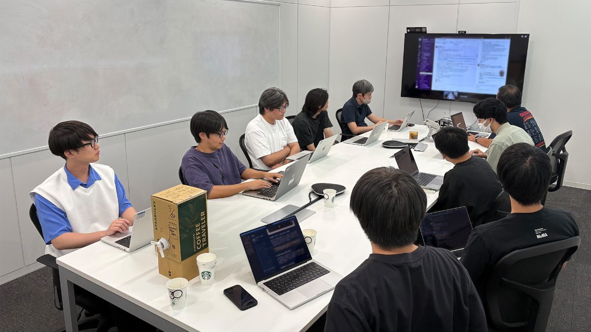 会議室に集まって社内LT会を行うエンジニアたち